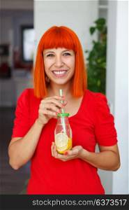 Red hair woman holding a lemonade at home