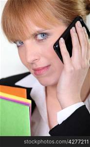 red-haired businesswoman with magnetic light blue eyes on the phone