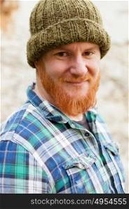 Red haired man with blue plaid shirt and wool hat