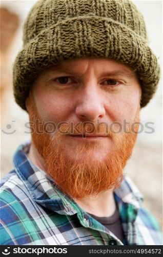 Red haired man with blue plaid shirt and wool hat