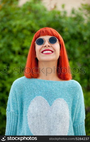 Red haired woman with cool sunglasses in a park