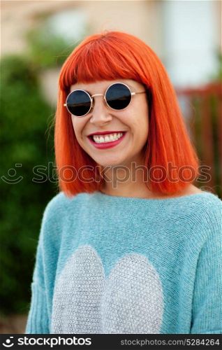 Red haired woman with cool sunglasses in a park