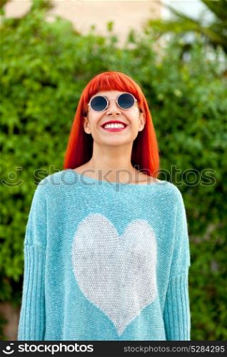 Red haired woman with cool sunglasses in a park