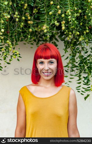 Red haired woman with yellow dress relaxed in a park