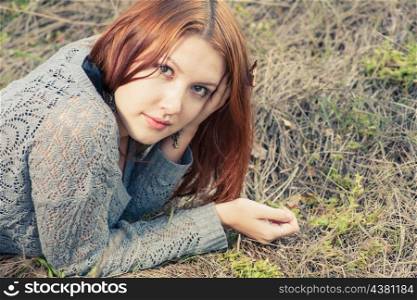 red haired women lying on autumn grass