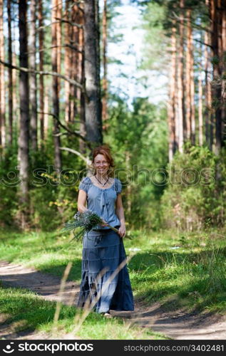 Red-haired women walking on path in the wood