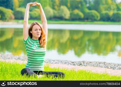red-haired young girl goes in for sports near the lake