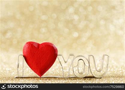 Red handmade wooden heart and words I love you on golden bright glitter lights bokeh background. Wooden heart and I love you