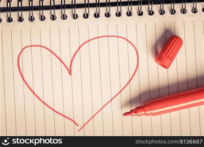 Red heart and a marker on a note
