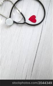 Red heart and a medical stethoscope, insurance,hospital,world health day concept top view on white wooden background copy space space for text. Red heart and a medical stethoscope, insurance,hospital,world health day concept top view on white wooden background copy space