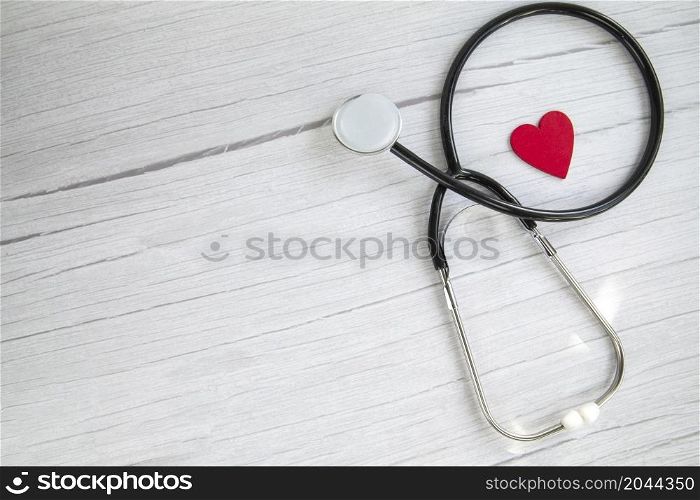 Red heart and a medical stethoscope, insurance,hospital,world health day concept top view on white wooden background copy space space for text. Red heart and a medical stethoscope, insurance,hospital,world health day concept top view on white wooden background copy space