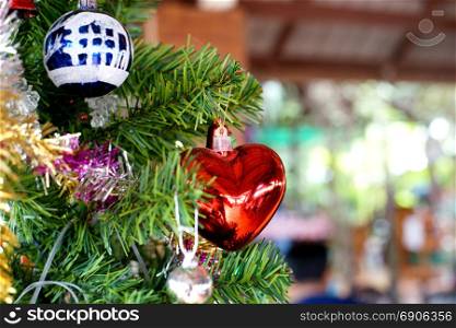 red heart and various christmas ornaments decorated on christmas tree
