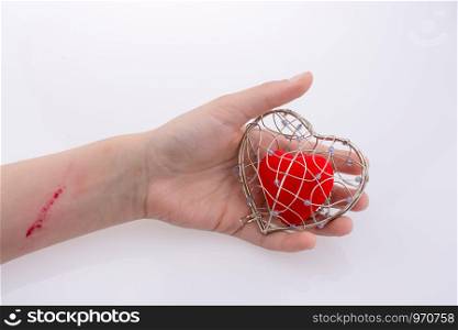 Red heart in a heart shaped cage