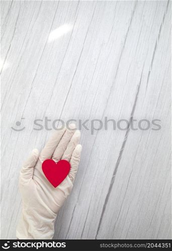 red heart in white protective medical gloves top view, background for the day of the medic, covid-19, coronavirus, hospital concept copy space space for text. red heart in white protective medical gloves top view, background for the day of the medic, covid-19, coronavirus, hospital concept copy space