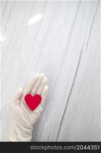 red heart in white protective medical gloves top view, background for the day of the medic, covid-19, coronavirus, hospital concept copy space space for text. red heart in white protective medical gloves top view, background for the day of the medic, covid-19, coronavirus, hospital concept copy space