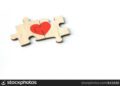 Red heart is drawn on the pieces of the wooden puzzle lying next to each other isolated on white background. Love concept. St. Valentine day. Copyspace.. Red heart is drawn on the pieces of the wooden puzzle lying next to each other isolated on white background. Love concept. St. Valentine day. Copy space.