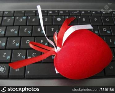 Red heart laying on the keyboard of notebook
