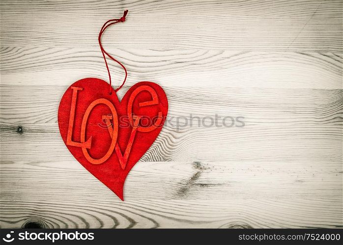 Red Heart Over Wooden Background. Love and Valentines Day Concept. Vintage style toned picture