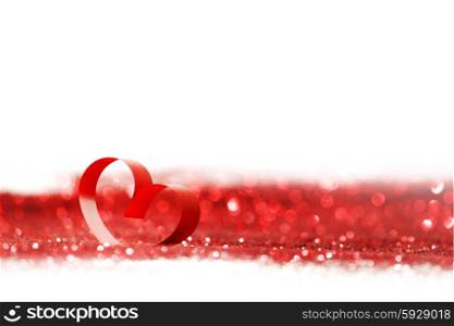 Red heart ribbon bow on glitters isolated on white background