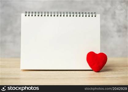 red heart shape and empty notebook on table for your text. Resolution, Goal, plan, health, Love, romantic and Valentine Day holiday Concept