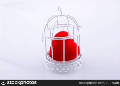 Red heart shape icon in metal wired cage