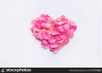 Red heart shape made from pink rose petals on white background.