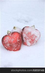 Red heart shaped ornaments in fresh fallen snow