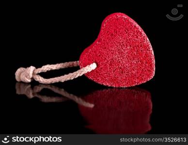 red heart-shaped stone with rope isolated on black