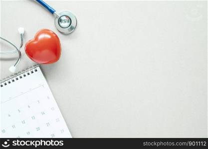 Red heart, stethoscope and calendar on white table with free space. Healthy check planning concept.