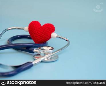 red heart using deep blue stethoscope on the blue background. Concept of love and caring patient by the heart. Copy space for the text and contents
