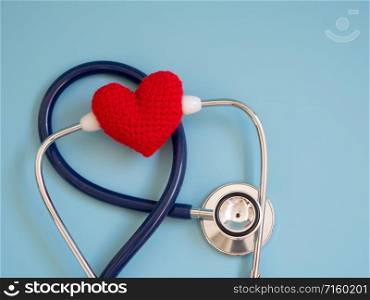 red heart using deep blue stethoscope on the blue background. Concept of love and caring patient by the heart. Copy space for the text and contents