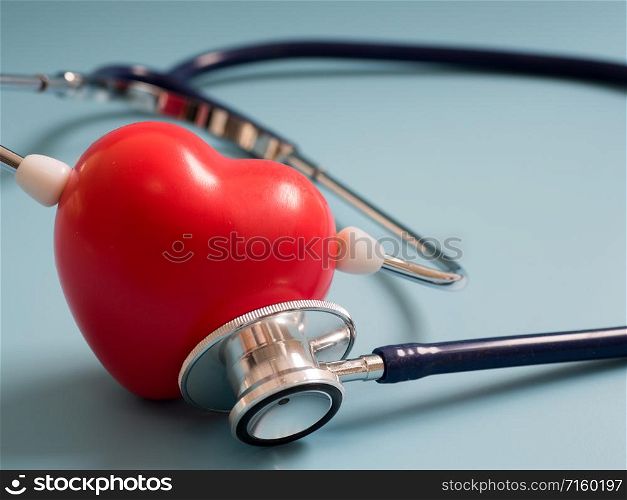 red heart using deep blue stethoscope on the blue background for hear their own heart. Concept of love and caring patient by the heart. Copy space for the text and contents