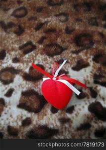 Red heart with red and white stripes on the brown background