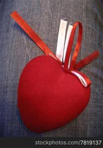 Red heart with red and white stripes on the jeans background