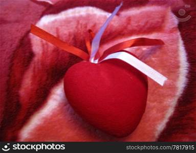 Red heart with red and white stripes on the pink background