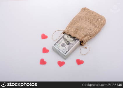 Red hearts and banknote bundle of US dollarin a sack