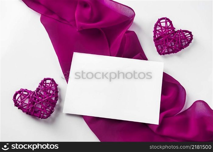 Red hearts and silk ribbon on a white background. Valentine&rsquo;s day empty greeting card on the background of two hearts and a red silk ribbon. Red hearts and silk ribbon on a white background