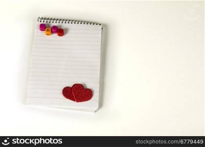 Red hearts and white paper sheet on white background