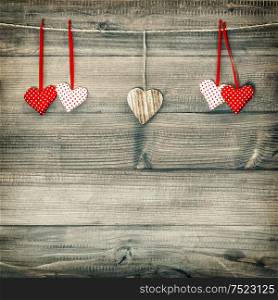 Red hearts hanging on clothesline over wooden background. Valentines Day concept