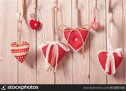 Red hearts hanging on the hooks.Christmas or Valentine greetings. Hearts on hooks