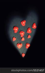 red hearts in light against black background