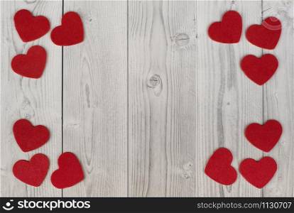 red hearts in the corners of a white and grey wooden background. concept of valentine's day