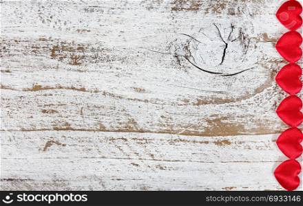Red hearts on rustic white wood in flat lay view