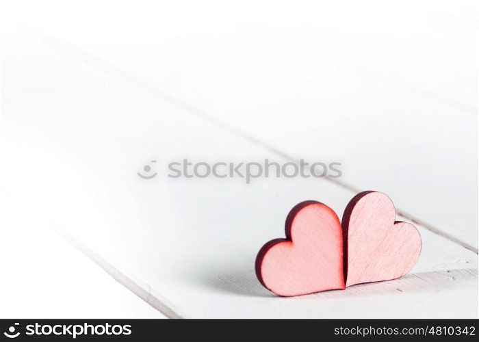 Red hearts on wood. Two small red hearts on white wooden background