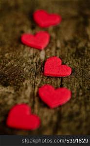 Red hearts stickers on wooden background in line, shallow DOF