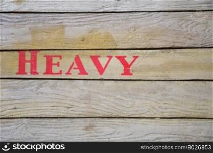 Red heavy word on wooden cardboard box