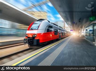 Red high speed train in motion on the railway station at sunset. Fast modern intercity train and blurred background. Railway platform. Railroad in Austria. Commercial and passenger transportation	