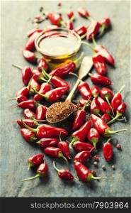 Red Hot Chili Peppers and olive oil over wooden background - cooking or spicy food concept