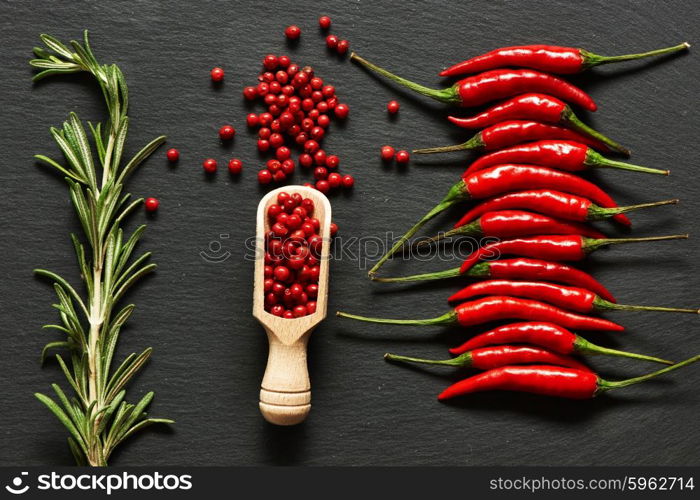 Red hot chili peppers and rose pepper on slate background