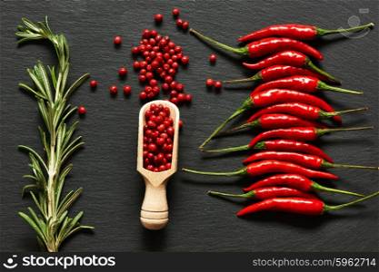 Red hot chili peppers and rose pepper on slate background